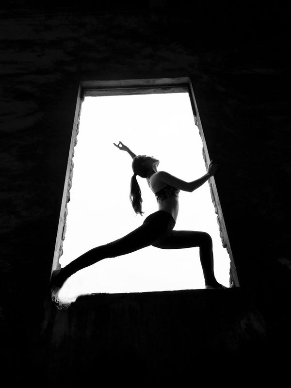 Elegant woman performing a flowing yoga movement.